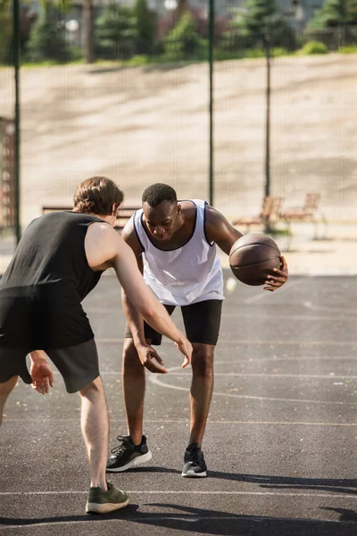 Африканский американец играет в баскетбол с другом на детской площадке — стоковое фото