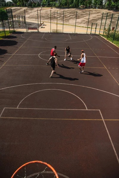 Vue en angle élevé de personnes multiethniques jouant au basket sur une aire de jeux à l'extérieur — Photo de stock