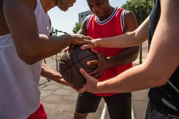 Des sportifs multiethniques tenant le ballon de basket à l'extérieur — Photo de stock