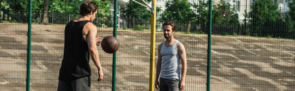 Hombres jugando baloncesto en la cancha, bandera - foto de stock