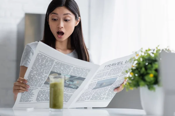 Изумленная азиатка читает газету 