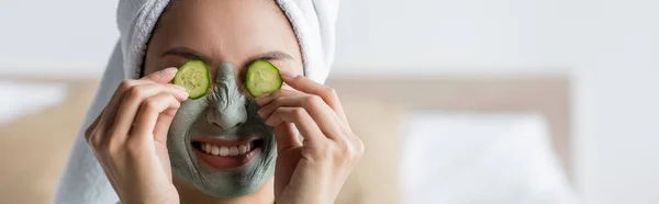 Sorrindo e franzindo a testa mulher aplicando fatias de pepino no rosto, banner — Fotografia de Stock