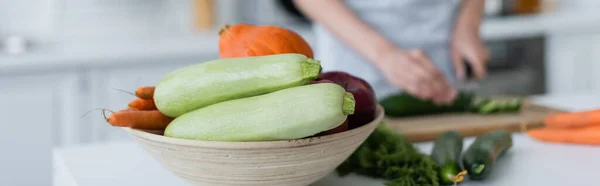 Foyer sélectif de bol avec des légumes frais près de femme floue préparer le petit déjeuner, bannière — Photo de stock