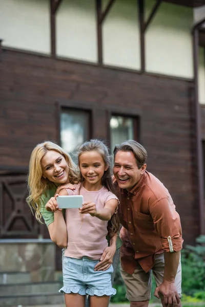 Famiglia sorridente scattare selfie su smartphone all'aperto — Foto stock