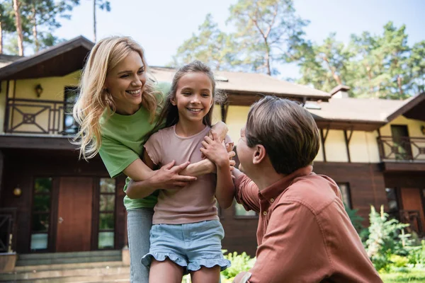 Mujer y niño abrazándose cerca de padre al aire libre - foto de stock