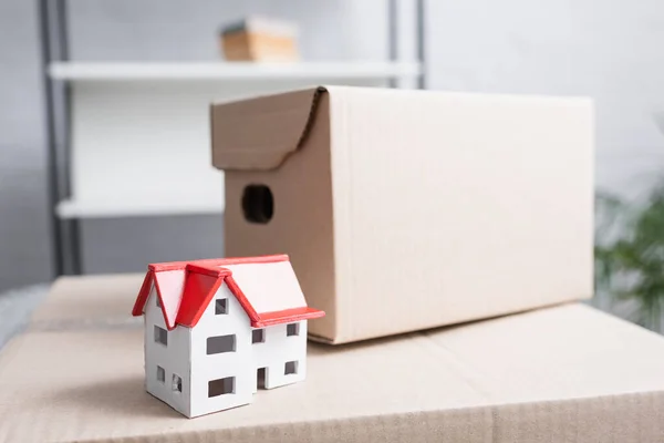 House model and package on cardboard box in new apartment — Stock Photo