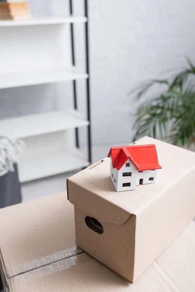 Vista de ângulo alto do modelo da casa em pacotes da caixa no apartamento novo — Fotografia de Stock