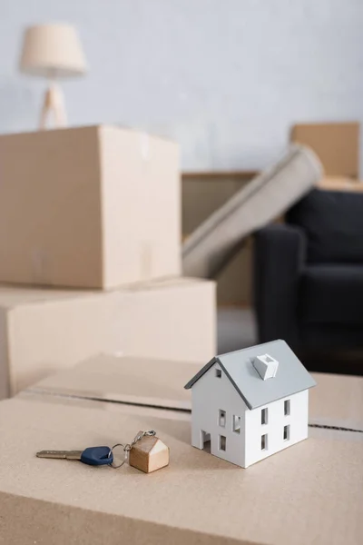 Modelo de casa e chave na caixa de papelão no novo apartamento — Fotografia de Stock