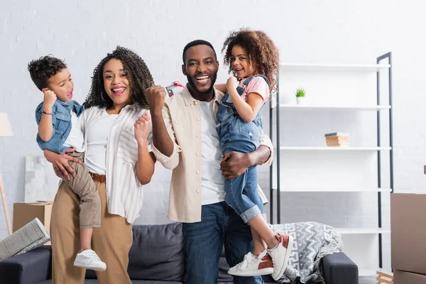 Heureuse famille afro-américaine montrant geste de succès dans le nouvel appartement — Photo de stock