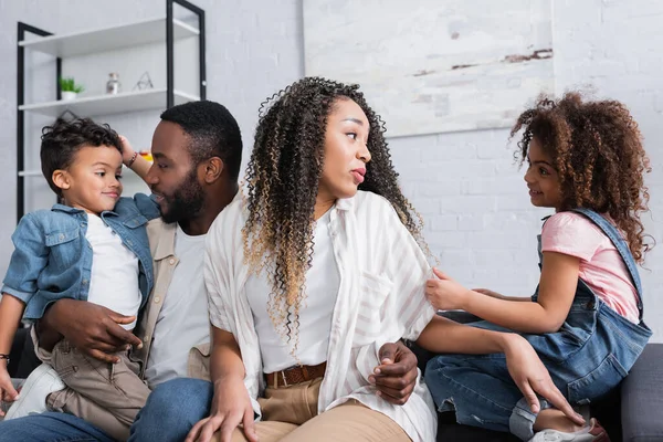 Positiva afro-americana família falando enquanto sentado no sofá em casa — Fotografia de Stock