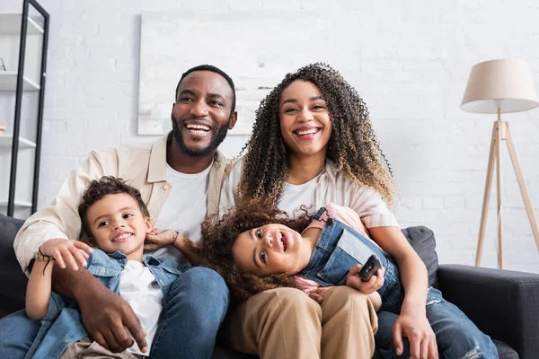 African american family laughing while watching comedy at home — Stock Photo