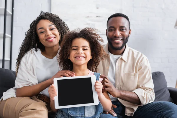 Menina americana africana feliz segurando tablet digital com tela em branco perto de pais felizes — Fotografia de Stock