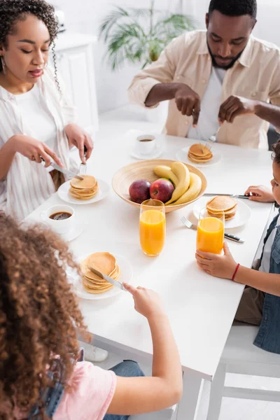 Familia afroamericana comiendo panqueques para el desayuno - foto de stock