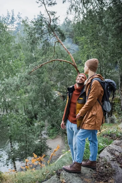 Повна довжина веселої пари тримає руки в лісі — стокове фото