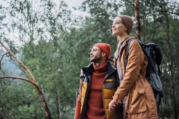 Junges und fröhliches Paar Händchen haltend im Wald — Stockfoto