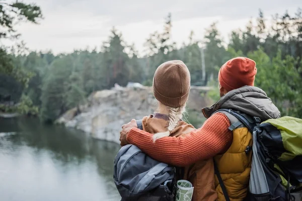 Vue arrière de l'homme étreignant femme près du lac — Photo de stock