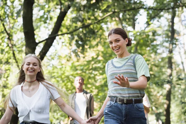 Sorrindo menina segurando mão de adolescente amigo no parque — Fotografia de Stock