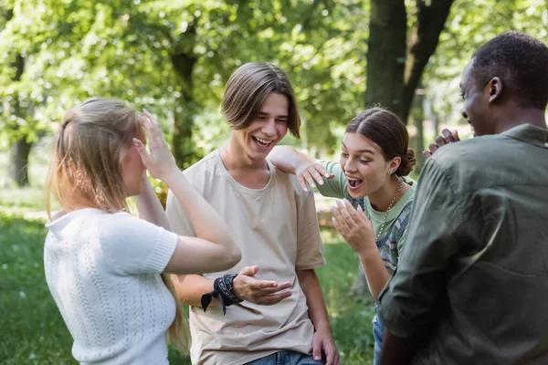 Positivo interracial adolescentes pasar tiempo juntos en parque - foto de stock