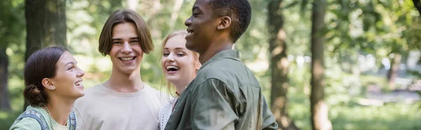 Positivos adolescentes interracial pasar tiempo en el parque, pancarta - foto de stock