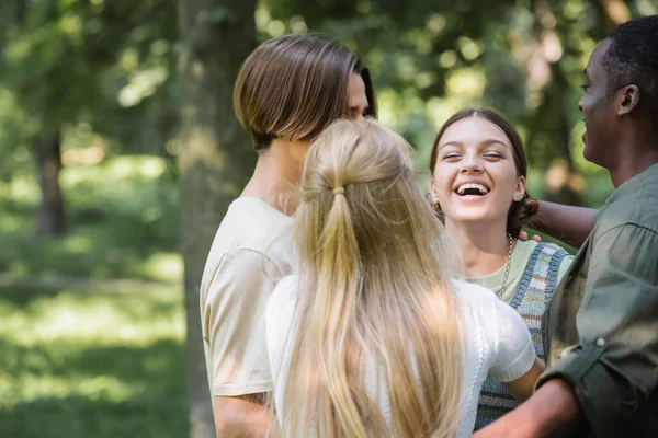 Adolescente afroamericano che abbraccia gli amici nel parco — Foto stock