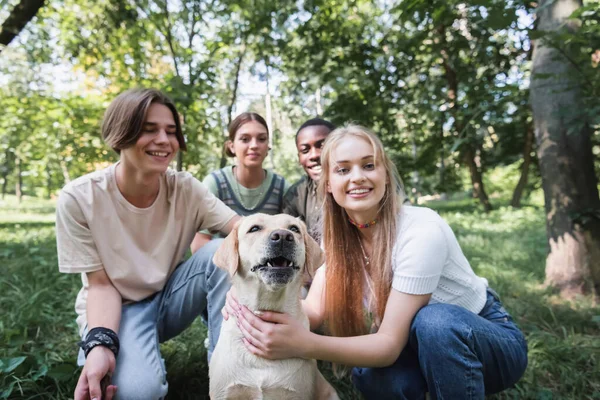 Récupérateur près des adolescents multiethniques flous dans le parc — Photo de stock