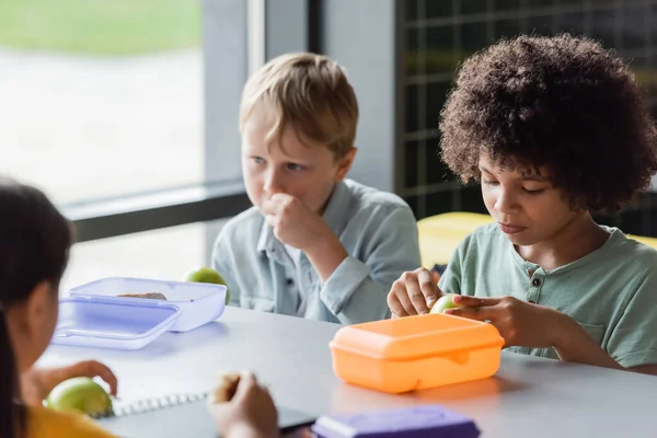 Niños interracial almorzando en el comedor de la escuela - foto de stock