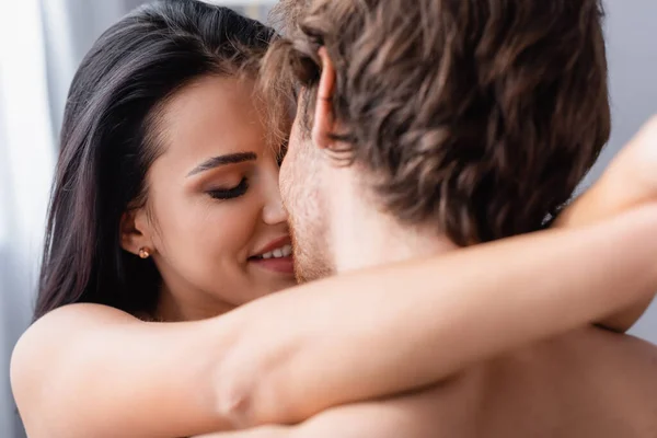 Primer plano de la mujer feliz abrazando al hombre sin camisa - foto de stock