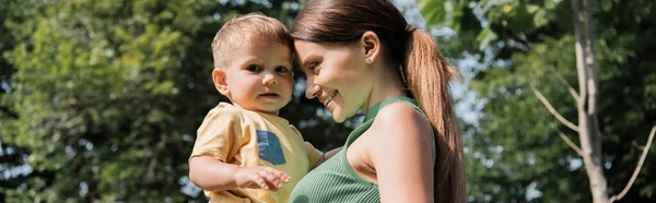 Lächelnde junge Mutter mit fröhlichem Kleinkind-Sohn im Arm, Banner — Stockfoto