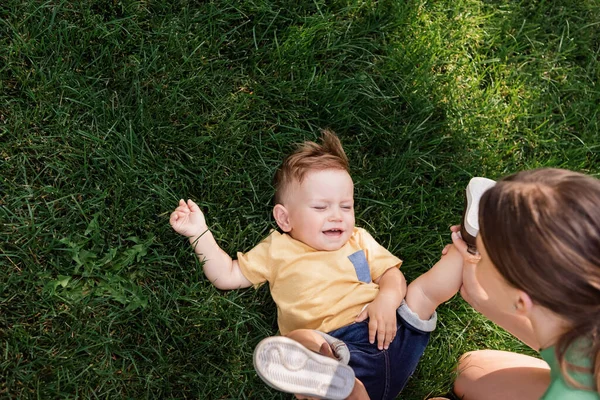 Vista de ángulo alto de la madre pasar tiempo con su hijo pequeño fuera - foto de stock