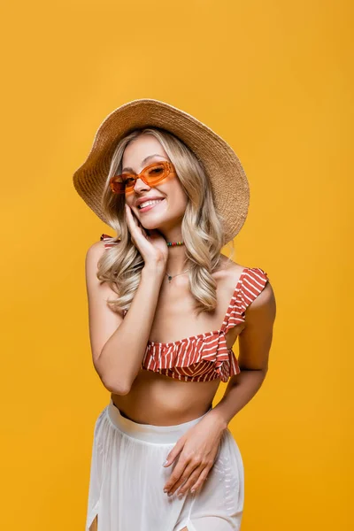 Heureux jeune femme à volants haut de bikini, jupe blanche et chapeau de soleil isolé sur jaune — Photo de stock