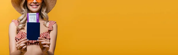 Vista cortada de mulher alegre no topo do biquíni ruffle segurando passaporte com bilhete de ar isolado no amarelo, banner — Fotografia de Stock