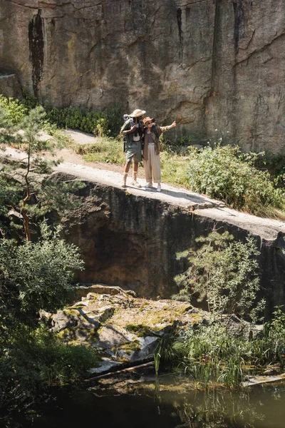 Старший путешественник указывает пальцем на африканского американского мужа и скалу — стоковое фото