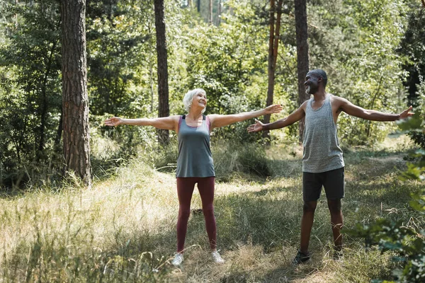 Souriant interracial couple formation ensemble dans la forêt — Photo de stock