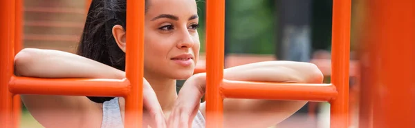 Deportista feliz mirando lejos cerca de naranja escalera vertical exterior, bandera — Stock Photo