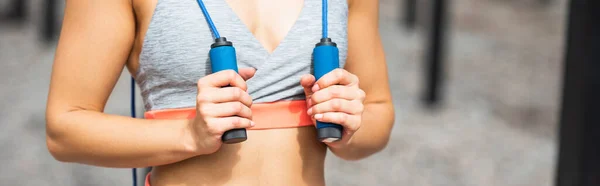 Cropped view of sportswoman holding jumping rope, banner — Stock Photo