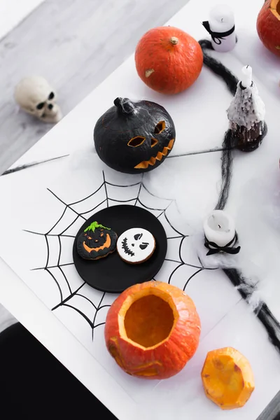 Top view of pumpkins and baked spooky cookies on halloween party — Stock Photo