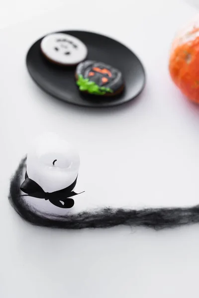 Candle near blurred halloween cookies and ripe pumpkin — Stock Photo