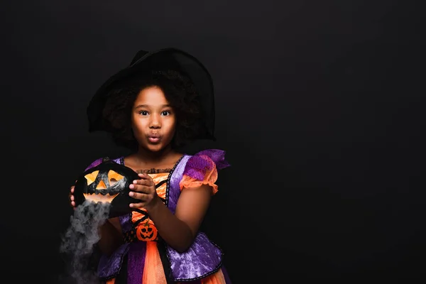 African american girl in halloween costume holding carved pumpkin isolated on black — Stock Photo