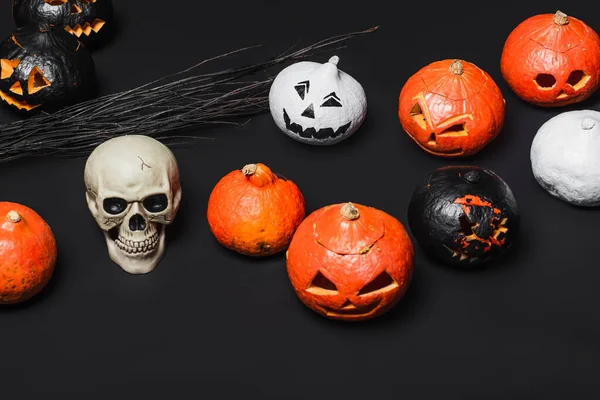 Skull near broom and carved pumpkins on black — Stock Photo