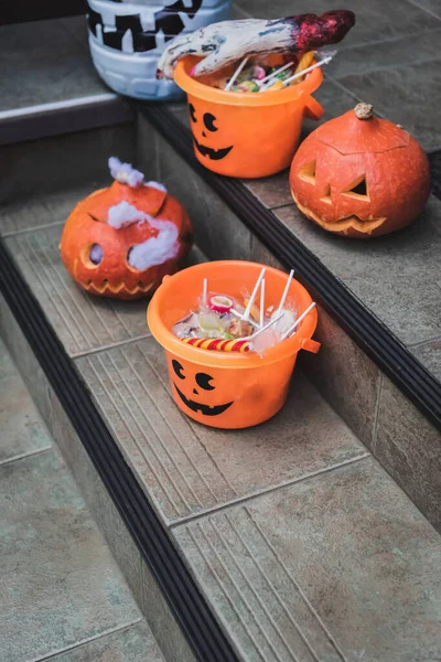 Halloween buckets with sweets and carved pumpkins on cottage stairs — Stock Photo