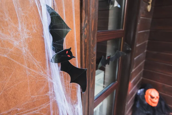 Puerta de la casa decorada con red de araña y papel negro murciélago cortado - foto de stock