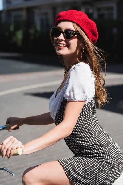 Glücklich junge Frau rote Baskenmütze und Sonnenbrille Fahrrad — Stockfoto