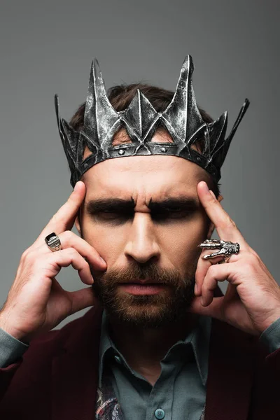 Thoughtful and serious man in vampire king halloween crown touching head isolated on grey — Stock Photo