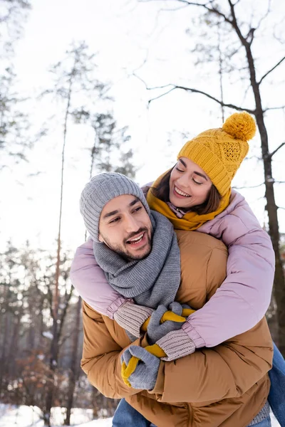 Mujer alegre abrazando novio en el parque de invierno - foto de stock