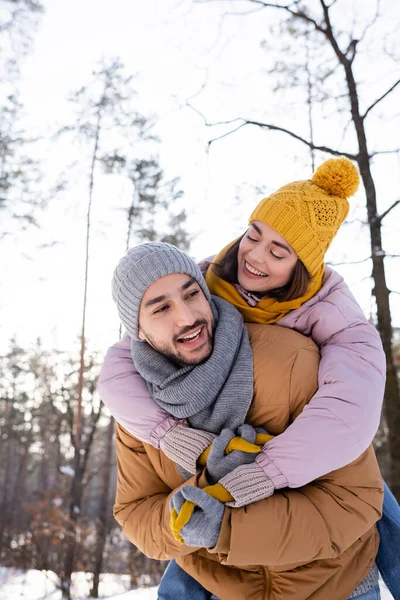 Mulher alegre abraçando namorado no parque de inverno — Fotografia de Stock