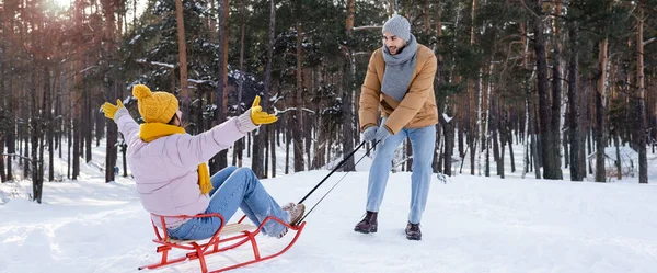 Couple excité s'amuser avec traîneau dans le parc d'hiver, bannière — Photo de stock