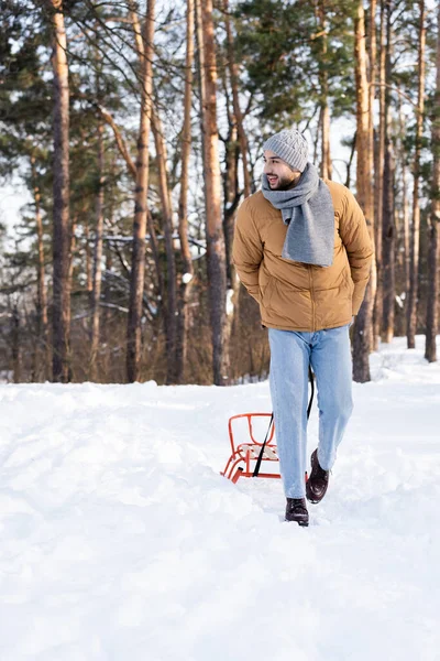 Bärtiger Mann zieht Schlitten im Winterpark — Stockfoto