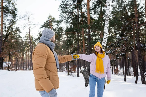 Lächelnde Frau hält Hand ihres Freundes im Winterpark — Stockfoto