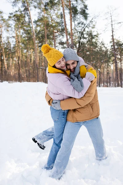 Casal alegre abraçando no parque nevado — Fotografia de Stock