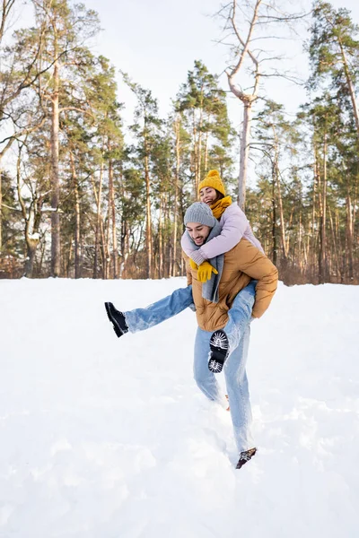 Young couple in winter outfit having fun in park with snow — Stock Photo